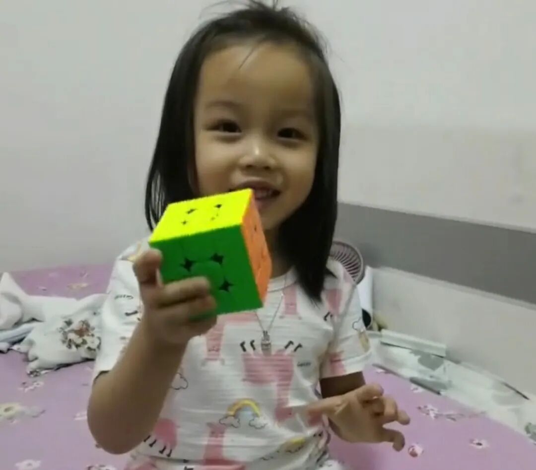 Deng Wanying as a toddler holding her first Rubik’s cube at home