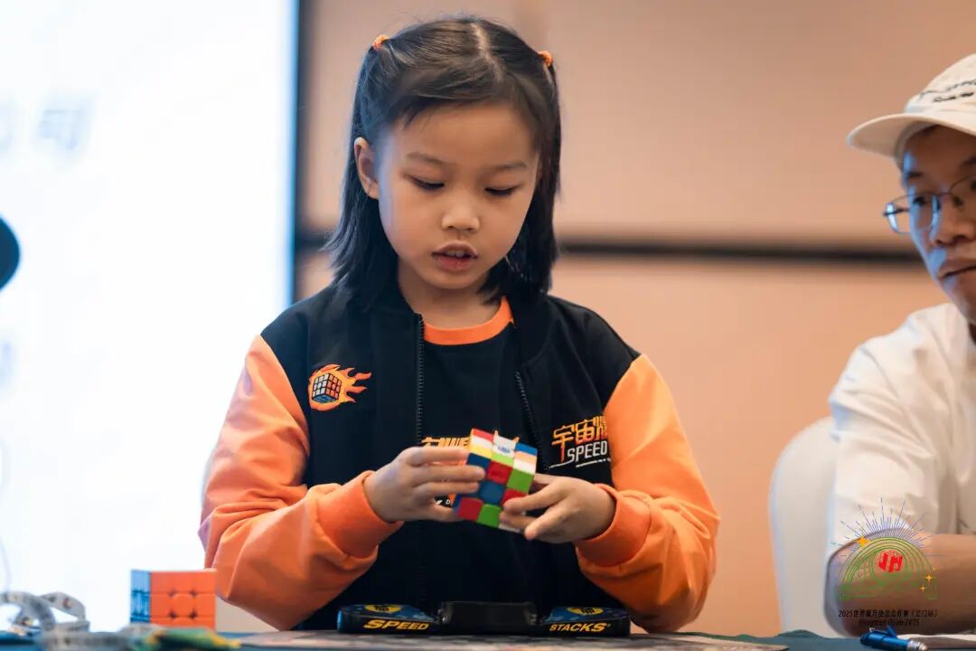 Deng Wanying competing on stage in a youth speedcubing event